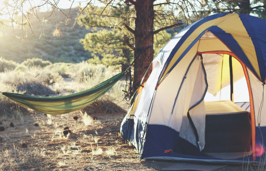 Oprema za kampiranje vključuje šotor in mrežo za ležanje.